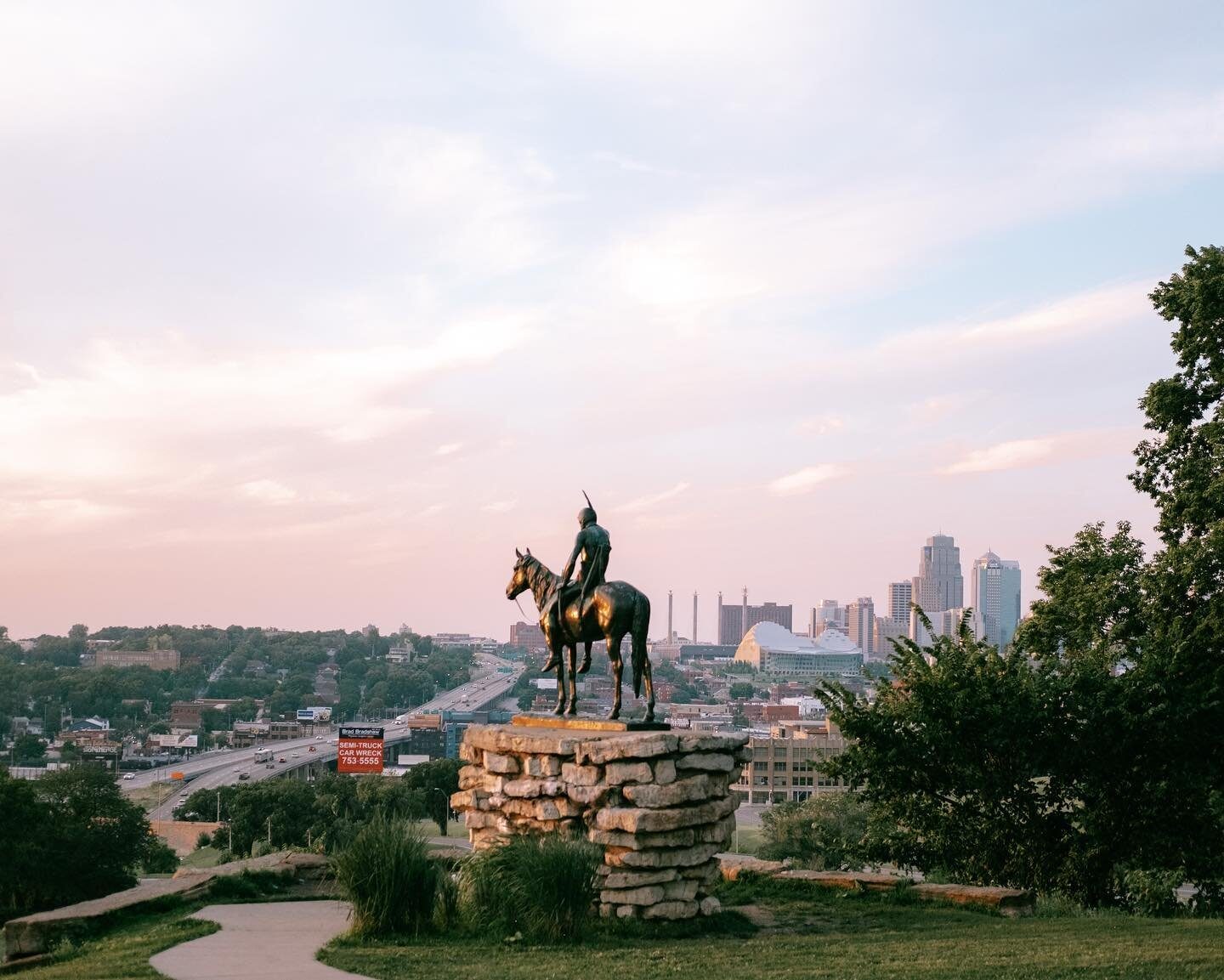 The Scout statue on horseback overlooking the Kansas City skyline at dusk